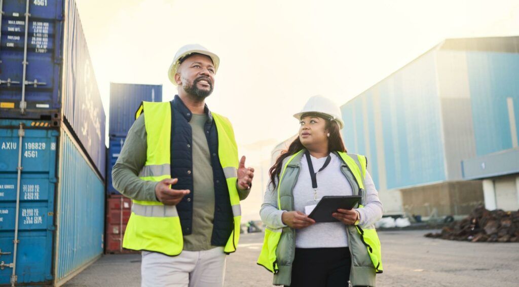 Port workers discussing the schedule for arriving cargo. business insurance for online retail